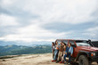 © Yakobchuk Olena - Pleasant happy young friends standing near their car while enjoying view from the mountain hill