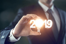 Closeup Hand Of Businessman Holding Light Bulb And Number 2019 Year, Business Idea New Year Concept.