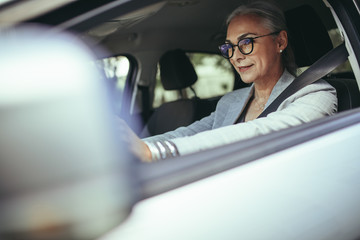 Senior female entrepreneur driving to office