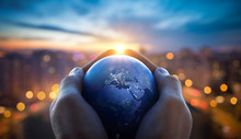 The Globe Earth In The Hands Of Man Against The Night City. Concept On Business, Politics, Ecology And Media. Earth Day Abstract Background. Elements Of This Image Furnished By NASA.