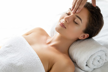 Young and beautiful woman during facial massage session