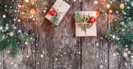 female hand reading a letter to santa on wooden background with christmas gifts, fir branches. xmas 