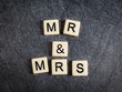 Letter tiles on black slate background spelling Mr & Mrs