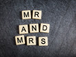 Letter tiles on black slate background spelling Mr and Mrs