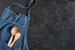 Blue denim apron with wooden spoons in the pocket