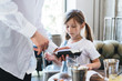 © teksomolika - Teen girl pays in the restaurant with a credit card