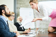 © pressmaster - Annoyed young elegant businesswoman showing paper to one of colleagues while looking at him at seminar