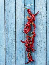 Red Raw Ripe Hot Chili Peppers Hanging On A Rope
