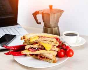 Wall Mural - quick lunch of sanwich on wooden table in the office near the laptop