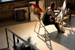 © Seventyfour - High angle view of handsome male artist painting on easel while enjoying work in sunlit art studio, copy space
