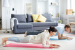 © pressmaster - Young man and woman in activewear doing plank during workout at home