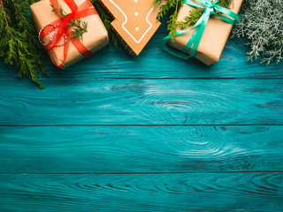 Christmas gift boxes on dark green wooden background with fir tree branches