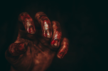 Fototapeta bloody dirty zombie hand on black background. halloween spooky poster