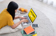 © weedezign - Asian female student  log on to e-learing website on laptop computer at home.woman lying down on carpet.learning online lifestyle.