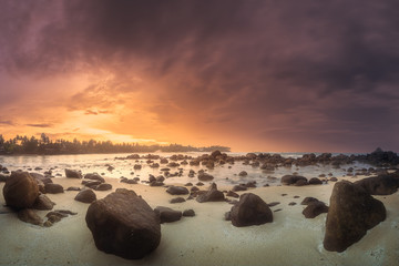 Wall Mural - tropical beach with rocks on sand coast of ocean