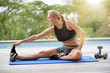 © goodluz - Woman doing fitness exercises outside by the pool