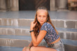© Aleksandr - teenage female dressed in jeans sits on stairs