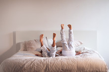Two Young Sisters (kids) With Pigiama Jump And Have Fun On The Bed. 