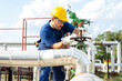 © zorandim75 - Oil worker turning valve on oil rig