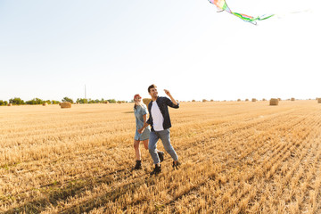 Happy young couple walking together at the wheat field