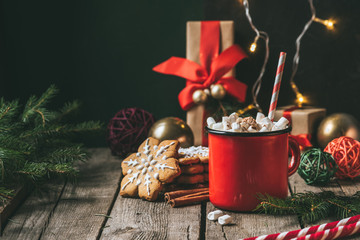 cup of hot cocoa with marshmallows on wooden table with christmas gingerbread