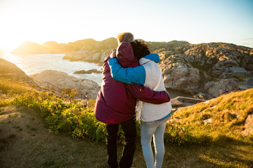 loving mature couple traveling, standing on the top of rock, exploring. active man and woman hugging