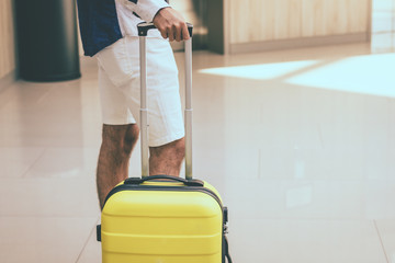  Man with suitcase waiting in a lobby.