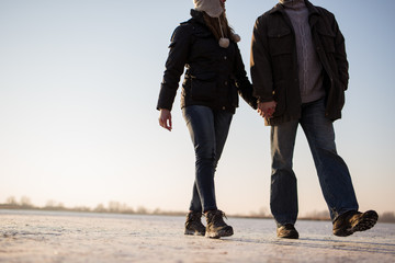 Wall Mural - Couple taking a romantic walk on frozen lake