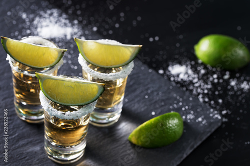Fotomural Golden tequila on black background