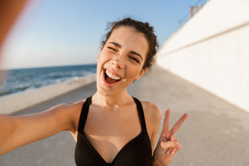 Wall Mural - Cheerful young sportswoman standing outdoors