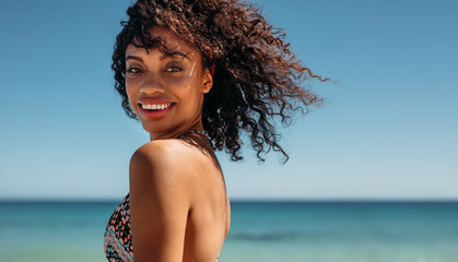 Wall Mural - Side view of a woman with curly hair at the beach