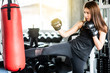 © ic36006 - Attractive female boxer training with kick boxing at gym with blackgloves.
