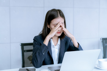 Asian business woman headache stressed because of work mistake problems about profit losses to be risk for fired from her job