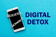 White Smartphone With Metal Chain On Blue Background. Digital Detox, Dependency On Tech, No Gadget And Devices Concept