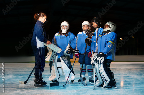 Fototapeta na szkło Female coach reviewing game plan with hockey team