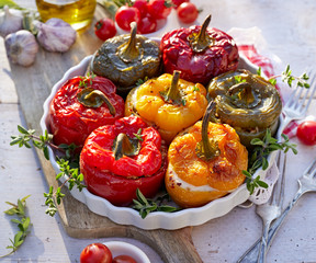 Wall Mural - Roasted bell pepper with mushroom, rice, cheese and herbs filling in a baking dish on a white wooden table, close-up. A healthy and delicious vegetarian food.