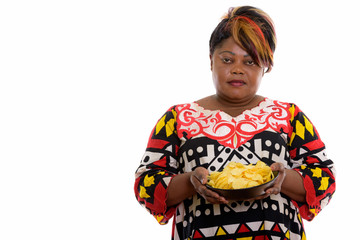 Studio shot of fat black African woman holding bowl of potato ch