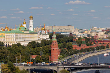 Moscow Kremlin with towers. Assumption Cathedral, in the Kremlin. Grand Kremlin Palace. The road near the Kremlin wall and the embankment near the river. Tourist ships sailing on the river.