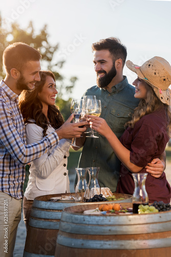 Cuadros en Lienzo Happy friends having fun drinking wine at winery vineyard - Friendship concept w