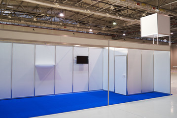 Exhibition stand design equipment. Booth template, Empty exhibition kiosk, with copy space, futuristic interior suspending lighting fixtures, shelves and tv screen.