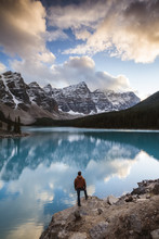 Rear View Of Man Looking At Moraine Lake While Standing On Rock In Banff National Park During Sunset