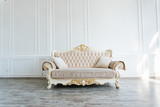 Fototapeta Na drzwi - beautiful expensive beige sofa against a white wall in an empty room