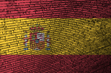 spain flag is depicted on the screen with the program code. the concept of modern technology and sit