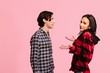 © Carlos David - Portrait of a couple in checkered shirts, isolated on pink studio background
