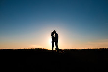 Romantic Couple Hug At Sunset On Background.