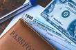 © Goffkein - Filling in the U.S. tax form. Tax form 1040, taxpayer passport, american hundred dollars and a pen on a wooden table. Financial concept, tax concept. Individual income tax return.