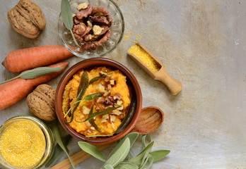 Wall Mural - Corn porridge / polenta / with roasted carrots, walnuts and sage, top view, copy space