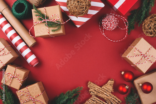 Christmas background with gift boxes, clews of rope, paper's rools and decora...