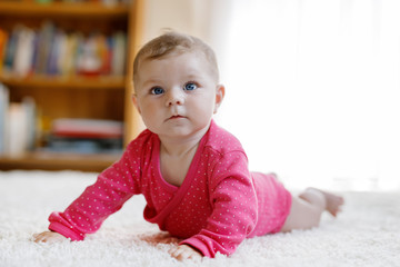 Portrait of little tiny baby girl of 5 months indoors at home