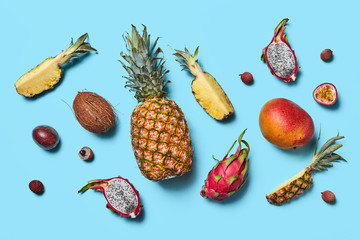 Wall Mural - Many different exotic fruits whole and halves presented on a blue background. Flat lay